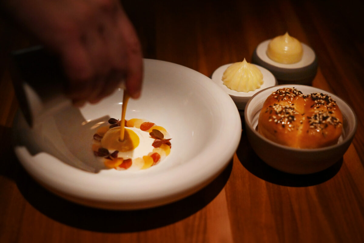 Honeynut squash velouté served over coins of pear, Ibérico ham and honeynut squash with a side of honey-glazed toasted Japanese milk bread at Auro restaurant in Calistoga, Calif. on Thursday, Dec. 8, 2022. (Erik Castro / For The Press Democrat)