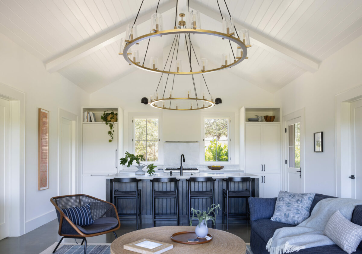 In the ADU, the kitchen blends seamlessly with the adjoining living room, with a white-paneled refrigerator, white cabinets that look like bookcases, and a kitchen island designed to resemble a piece of furniture. (Suzanna Scott)