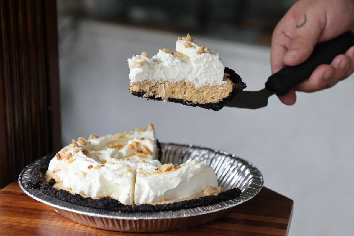 Owner Christian Sullberg cuts a slice of Peanut Butter Pie at Noble Folk Ice Cream and Pie Bar in Santa Rosa, Calif. on Tuesday, November 1, 2022. (Beth Schlanker/The Press Democrat)