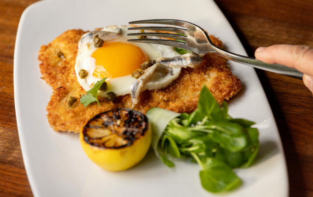 Holstein Schnitzel with fried farm egg, fresh anchovies, crispy capers and watercress from Tisza Bistro chef/owner Krisztian Karkus Monday, February 12, 2024 in Healdsburg. (Photo by John Burgess/The Press Democrat)