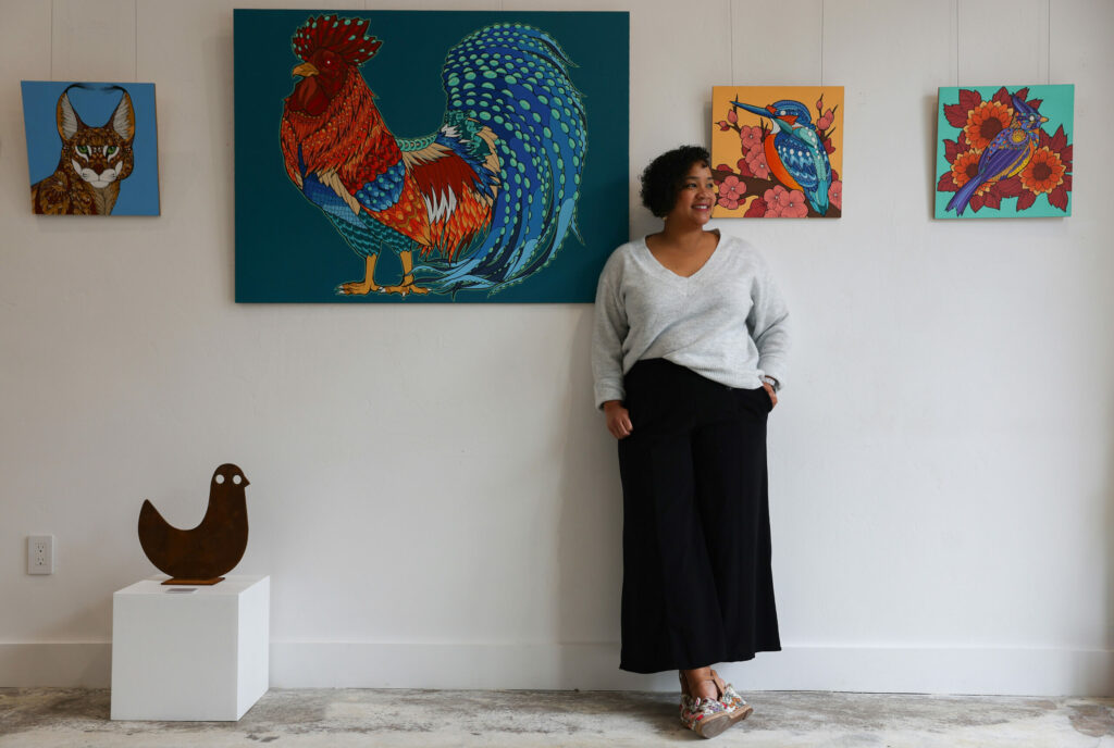 Rena Charles, among paintings by Lina Chambliss and a sculpture by Jeffie Brewer, in her Rena Charles Gallery in Healdsburg. (Christopher Chung/for Sonoma Magazine)