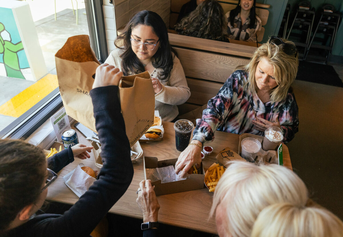 Rosie Padilla, left, and Carrie Reindahl dig into lunch with friends at the new Montgomery Village Shake Shack Wednesday, February 28, 2024 in Santa Rosa. (Photo by John Burgess/The Press Democrat)