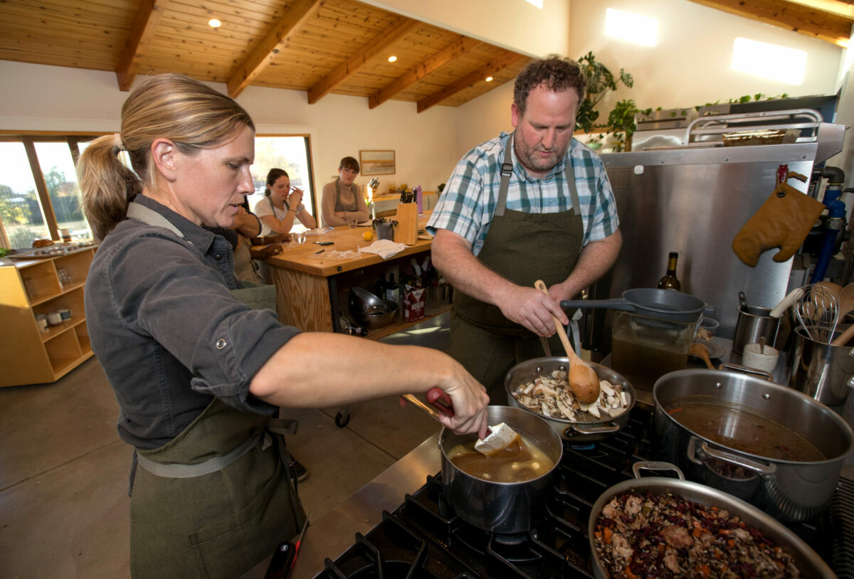Laci Sandoval and Dan Kedan cook as students watch in background, during a class called Hosting The Holiday Feast at the Wind & Rye Kitchen in Penngrove, Saturday, November 11, 2023. (Darryl Bush / For The Press Democrat)