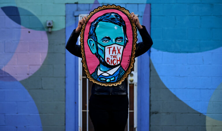 Santa Rosa-based street artist, The Velvet Bandit, a single mother of two children, displays a "Tax the Rich" painting, Thursday, Sept. 16, 2021. The font and the style of the wording resembles Rep. Alexandria Ocasio-Cortez (D-N.Y.) dress at the Metropolitan Museum of Art's Costume Institute benefit gala on Sept. 13. (Kent Porter / The Press Democrat) 2021