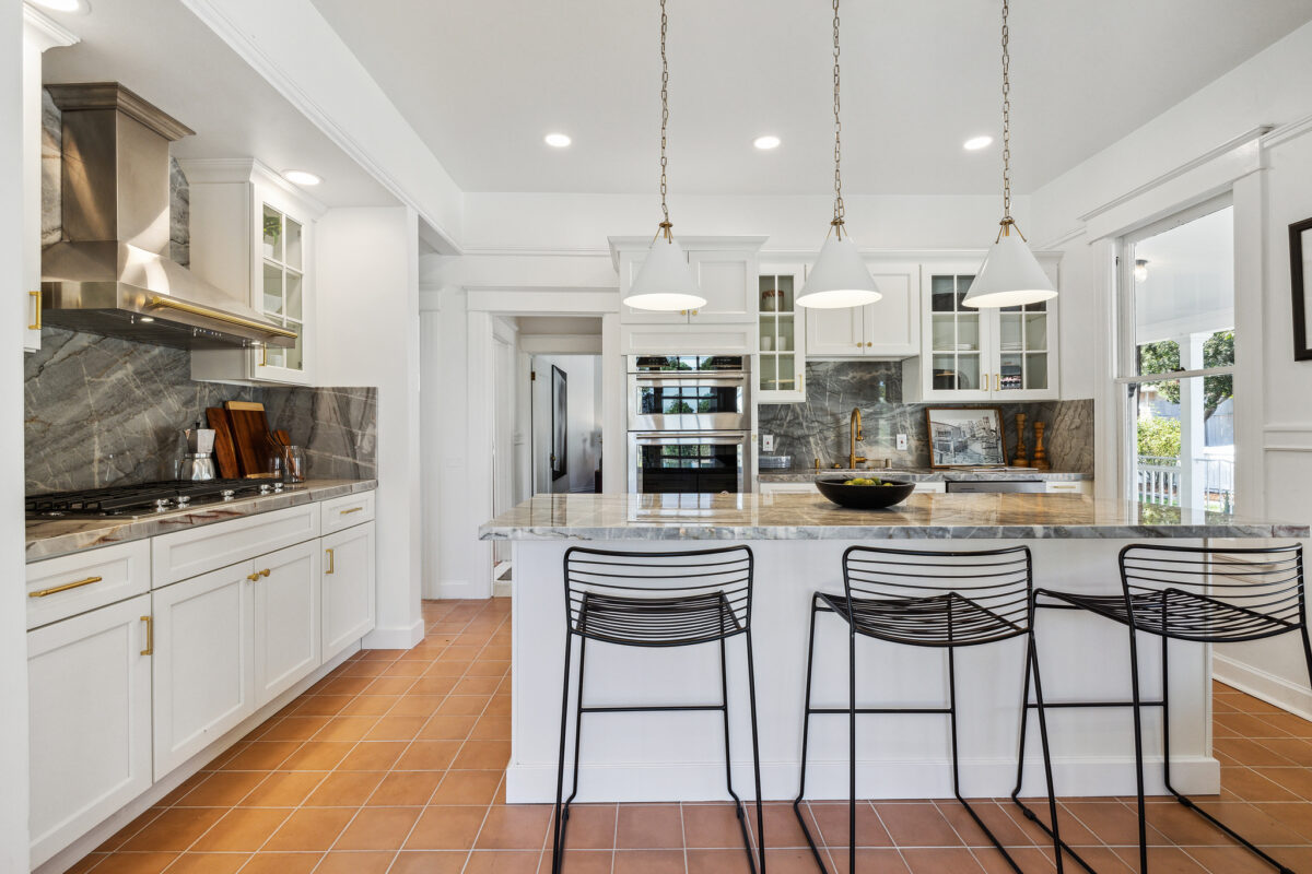 The kitchen has been stylishly renovated with lots of granite, new appliances and brass fixtures. (Open Homes Photography)