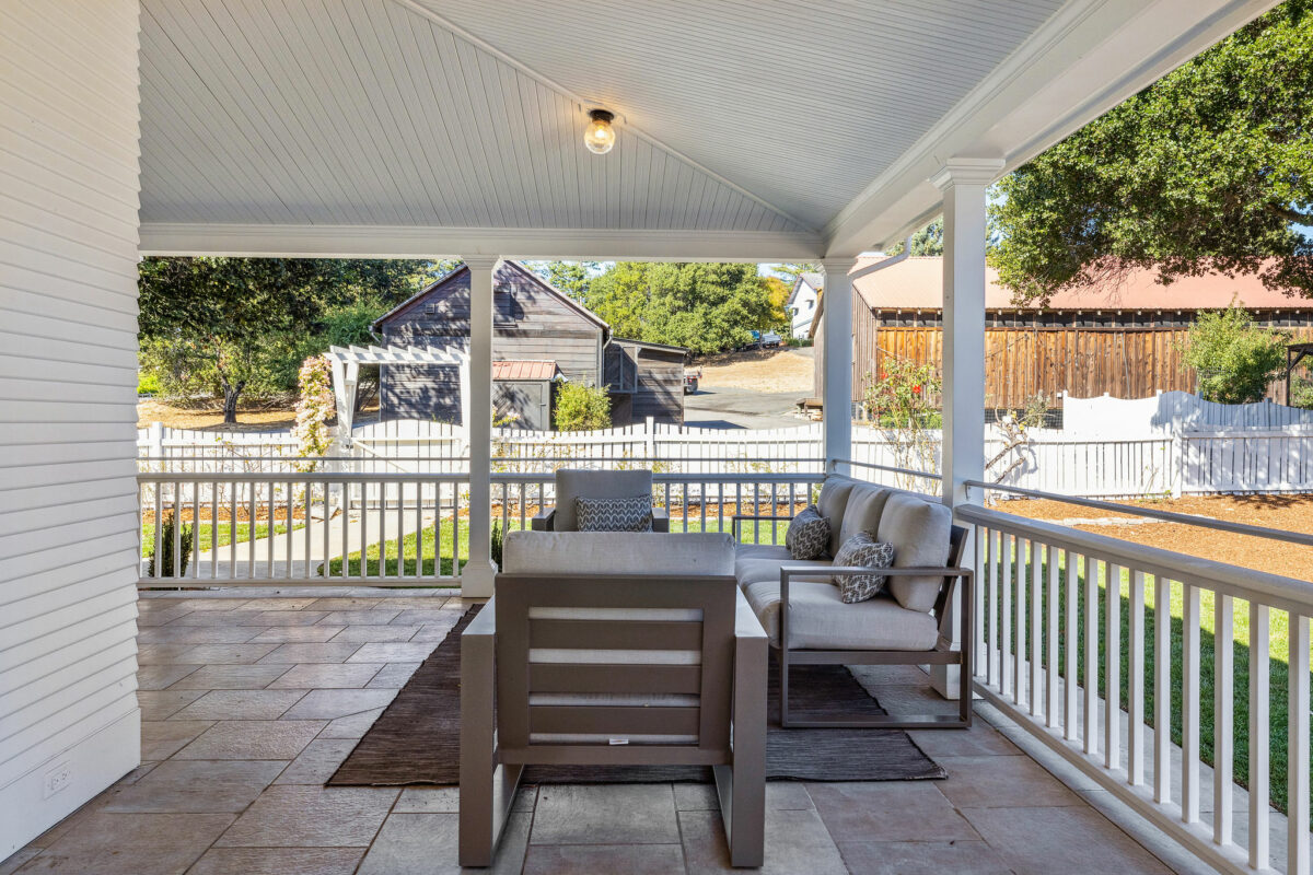 The wraparound porch overlooks the long barn and barn cottage. (Open Homes Photography)