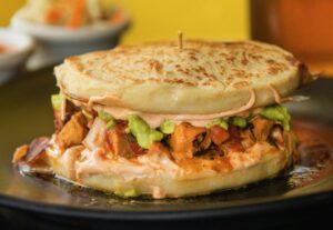 Orange Marinated Chicken Pupusa Burger with choice of two stuffed pupusa's filled with pico de gallo, guacamole, lettuce, cheese and chipotle cream from Don Julio's Latin Grill & Pupusas in Rohnert Park on Monday, August 31, 2020. (Photo by John Burgess/The Press Democrat)