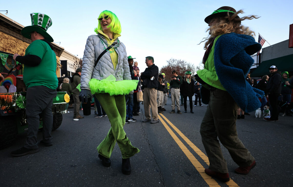 Healdsburg residents Holly Berkeley, left, and Robin Parvin dance a jig during Healdsburg's St. Patrick's Day Parade, Friday, March 17, 2023. (Kent Porter / The Press Democrat)
