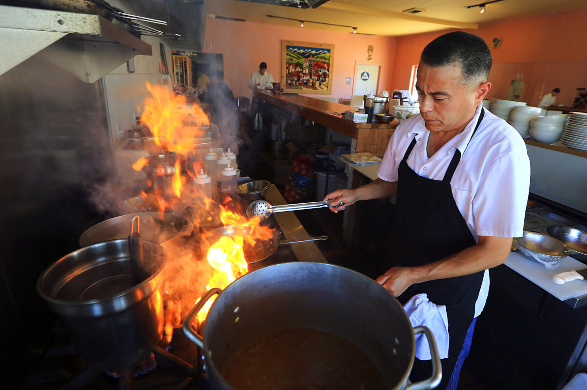 Alex Ruiz prepares a traditional Peruvian dish at Quinua Cocina Peruana in Petaluma. (John Burgess/The Press Democrat)