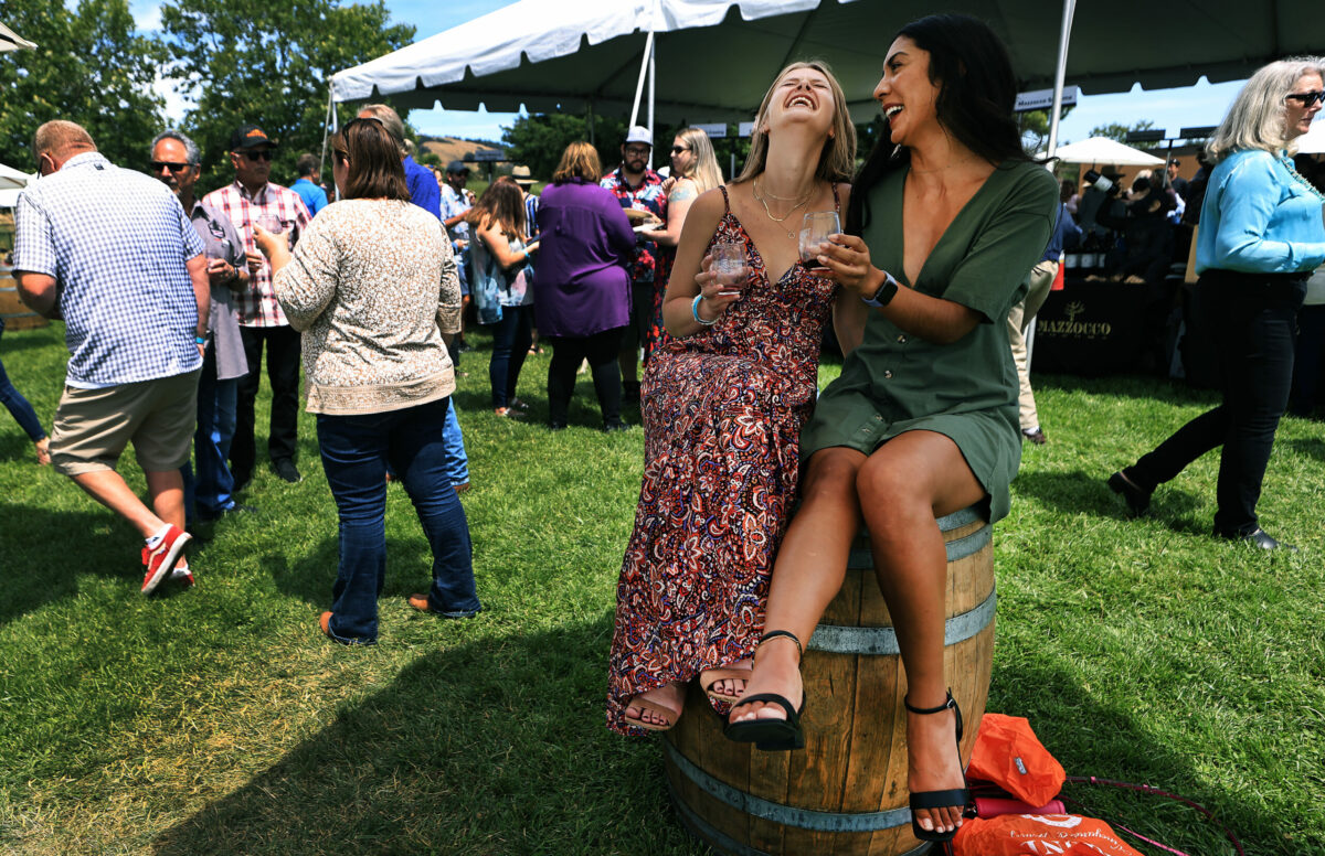 Roommates Amanda Harrison, left, and Abby Vidana enjoy their afternoon at the North Coast Wine and Food Festival at the Luther Burbank Center for the Arts in Santa Rosa, Saturday, June 17, 2023. They are from San Jose. (Kent Porter / The Press Democrat)