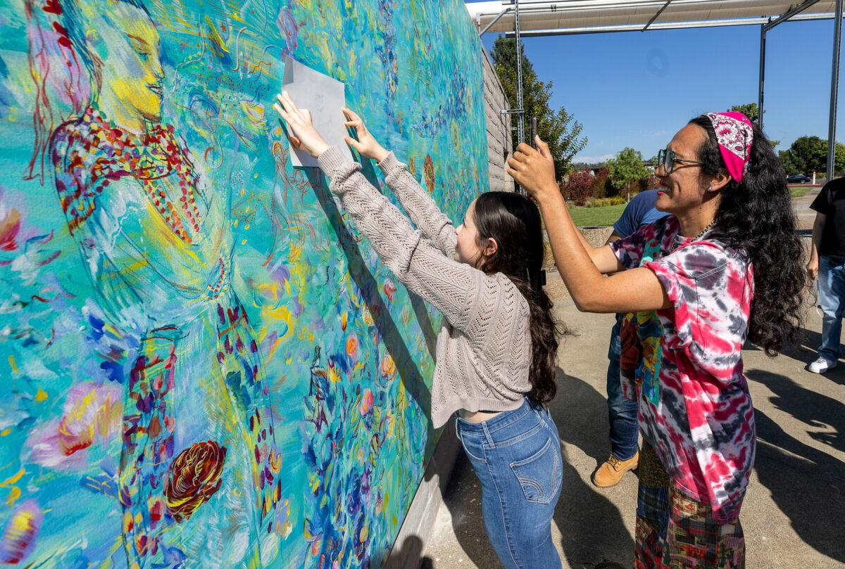 Artist Maria de Los Angeles takes a picture of Karla Garcia’s drawing and where she would like it to be placed on a community-focused mural at the Luther Burbank Center for the Arts in Santa Rosa, Tuesday, Aug. 1, 2023. De Los Angeles worked with the Latino Service Providers and other local groups to integrate their ideas into a second mural at the arts center. (John Burgess / The Press Democrat)