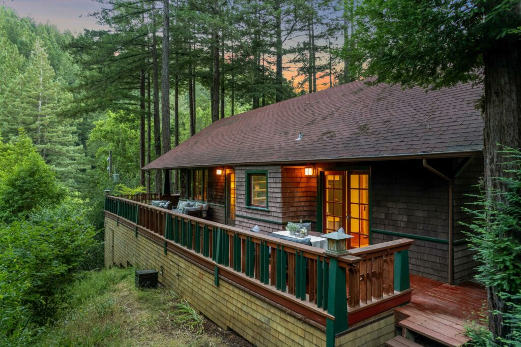 The wraparound porch offers dining and lounging space with forest views.(Open Homes Photography)