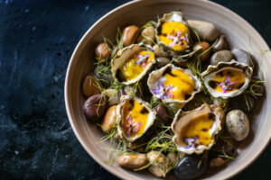 Ostiones (oysters) with mango leche de tigre, burnt scallion oil and borage blossoms from Arandas Friday, June 28, 2024 in Healdsburg. (Photo by John Burgess/The Press Democrat)