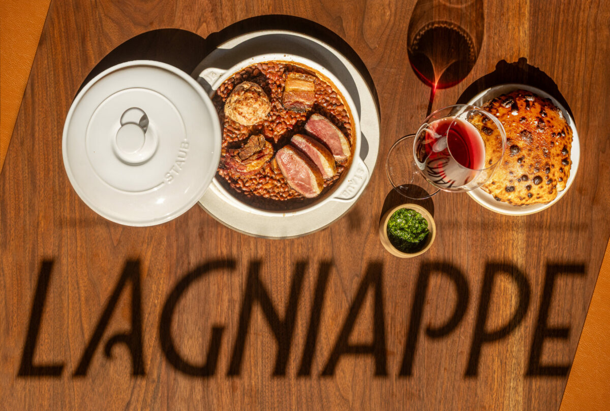 The shadow from a sign in the front window falls upon a table with cassoulet, duck confit, lamb and red peas at Bistro Lagniappe Thursday, June 19, 2025 in Healdsburg. (John Burgess / The Press Democrat)