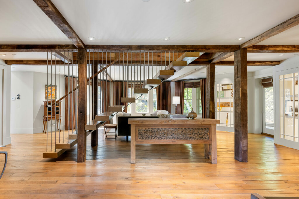 The modern metal stairway contrasts with the rustic style of the wood beams. (Sea Timber Media)