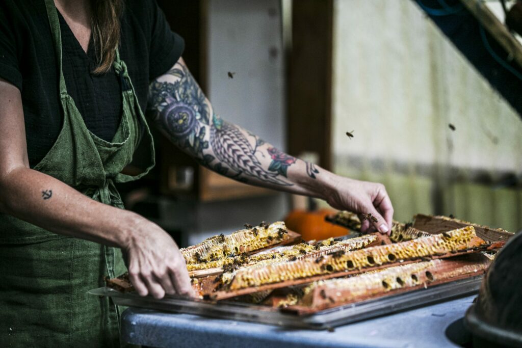At harvest, Candice Koseba slices the comb from the frames to crush it. The smell of honey can attract bees. (Bryan Meltz/Sonoma Magazine)