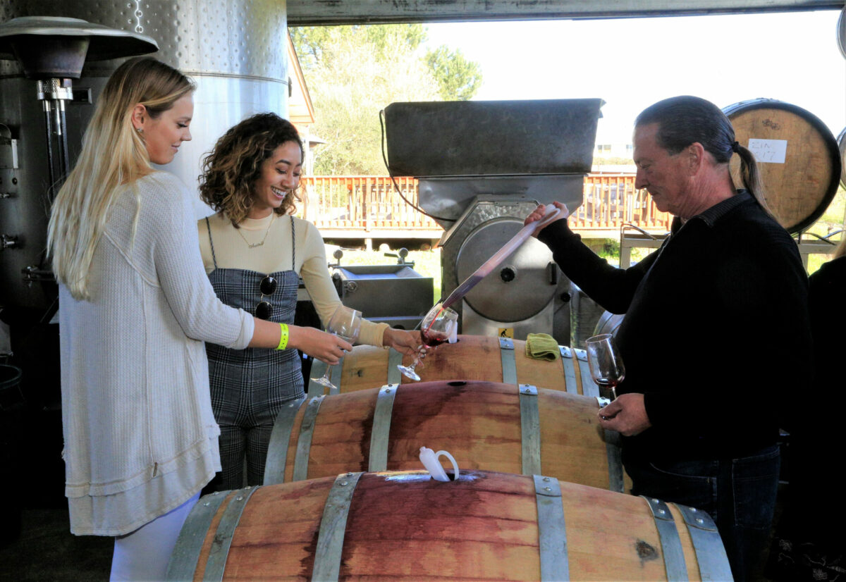 Rick Goodson, right, poured barrel samples for Masha Yelsukova, left, and Amira Dahdouh at Sunce Winery, Sunday, March 11, 2018. The Wine Road Barrel tasting weekends offer the opportunity to sample wines straight from the barrel, talk to winemakers and explore the beautiful Alexander, Dry Creek and Russian River Valleys. (Will Bucquoy/For the Press Democrat)