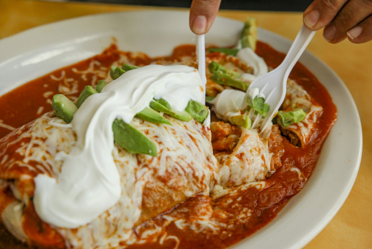 Alvaro Dueñas dives into his super wet burrito at Chunky’s Taqueria in east Petaluma. Photographed on Monday, February 5, 2024. (Crissy Pascual / Petaluma Argus-Courier)