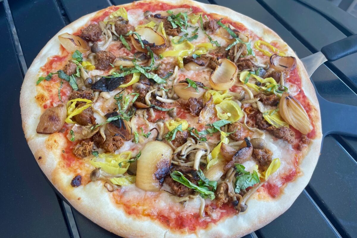 The Pearl, a thin-crust, wood-fired vegan pizza with tomato sauce, mozzarella, sausage, fennel pollen, mushrooms, caramelized red pearl onions, pepperoncini and basil at Wild Goat Bistro in Petaluma. (Tina Caputo)
