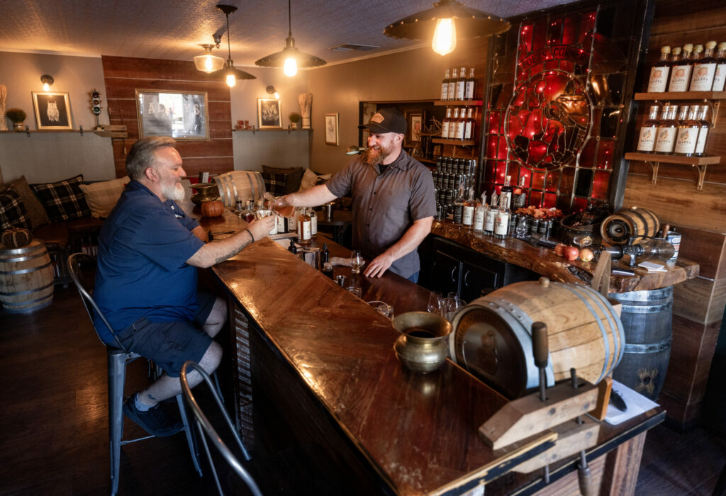 Owner Jason Jorgensen serves up a splash of “The Juice” for long-time customer Morris Dodge at Alley 6 Craft Distillery in a Healdsburg industrial park Tuesday, October 8, 2024. (John Burgess / The Press Democrat)