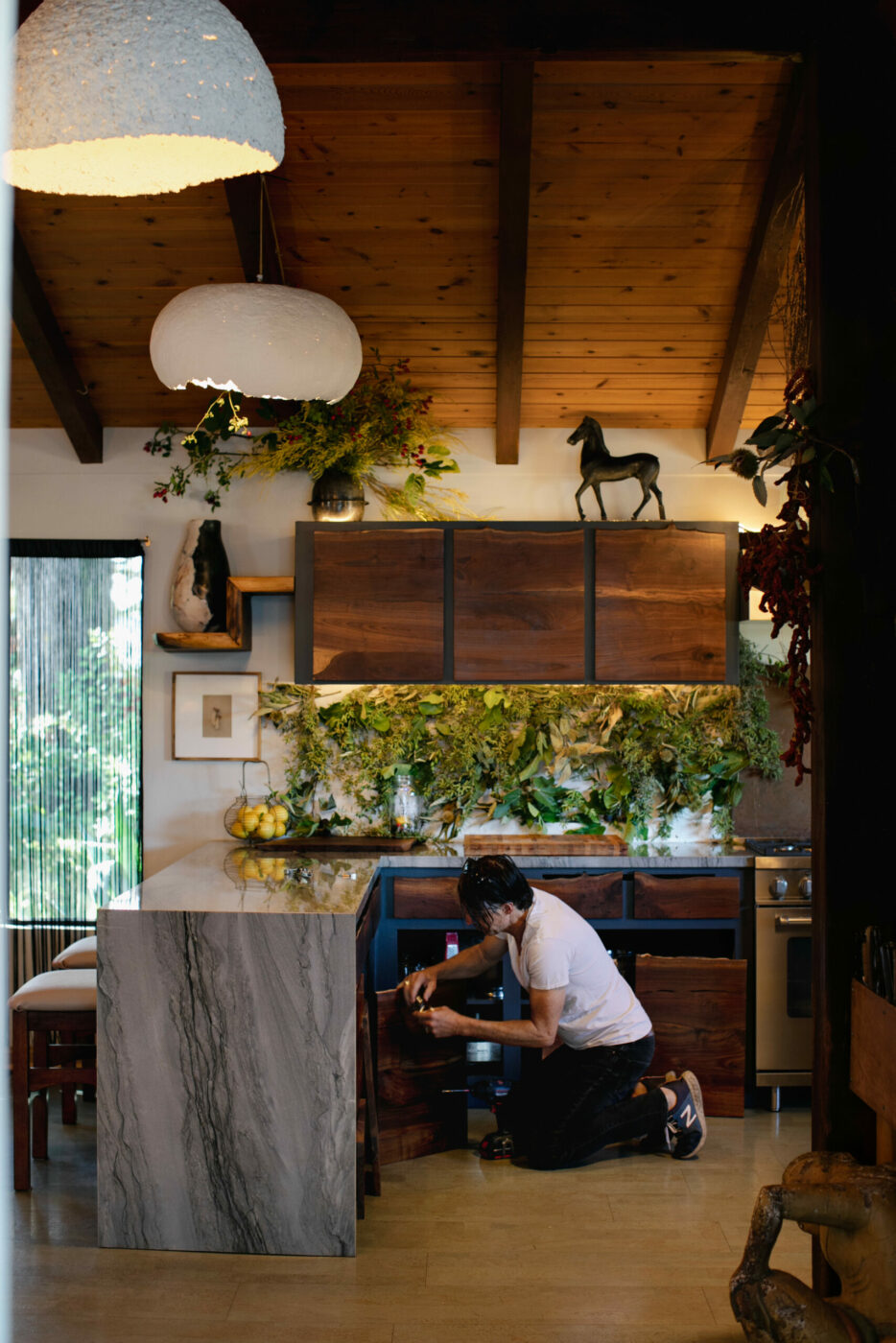 In the kitchen, Brook Bannister installs new, live-edge walnut cabinet fronts. (Eileen Roche / Sonoma Magazine)