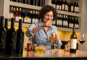 Land + Local owner Kim LaVere mixes a Blood Orange Venetian using her Blood Orange and Fennel seasonal syrup with a dash of nonalcoholic bitters, an offering for designated drivers at Merriam Vineyards Monday, April 29, 2024, in Healdsburg. (John Burgess/The Press Democrat)