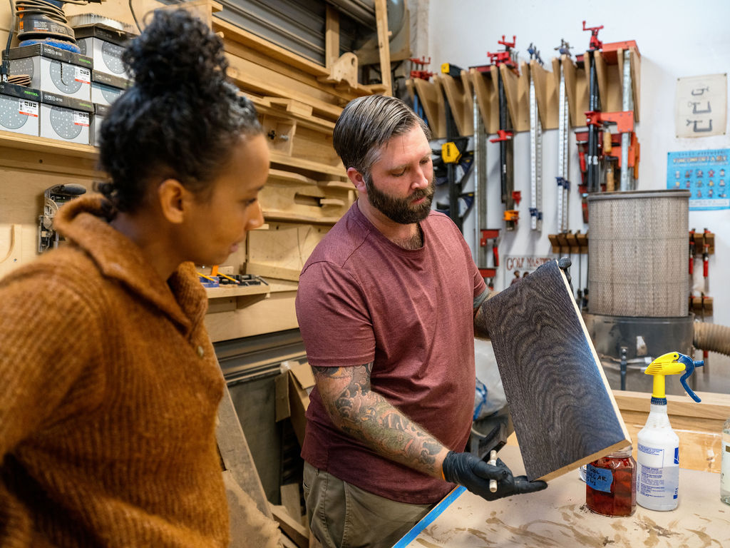 The homeowners’ son, Ross Peters, of Ross Woodworking, explains the natural process by which he creates a dark stain for his parents’ dining room table. (Mike Murtaugh)