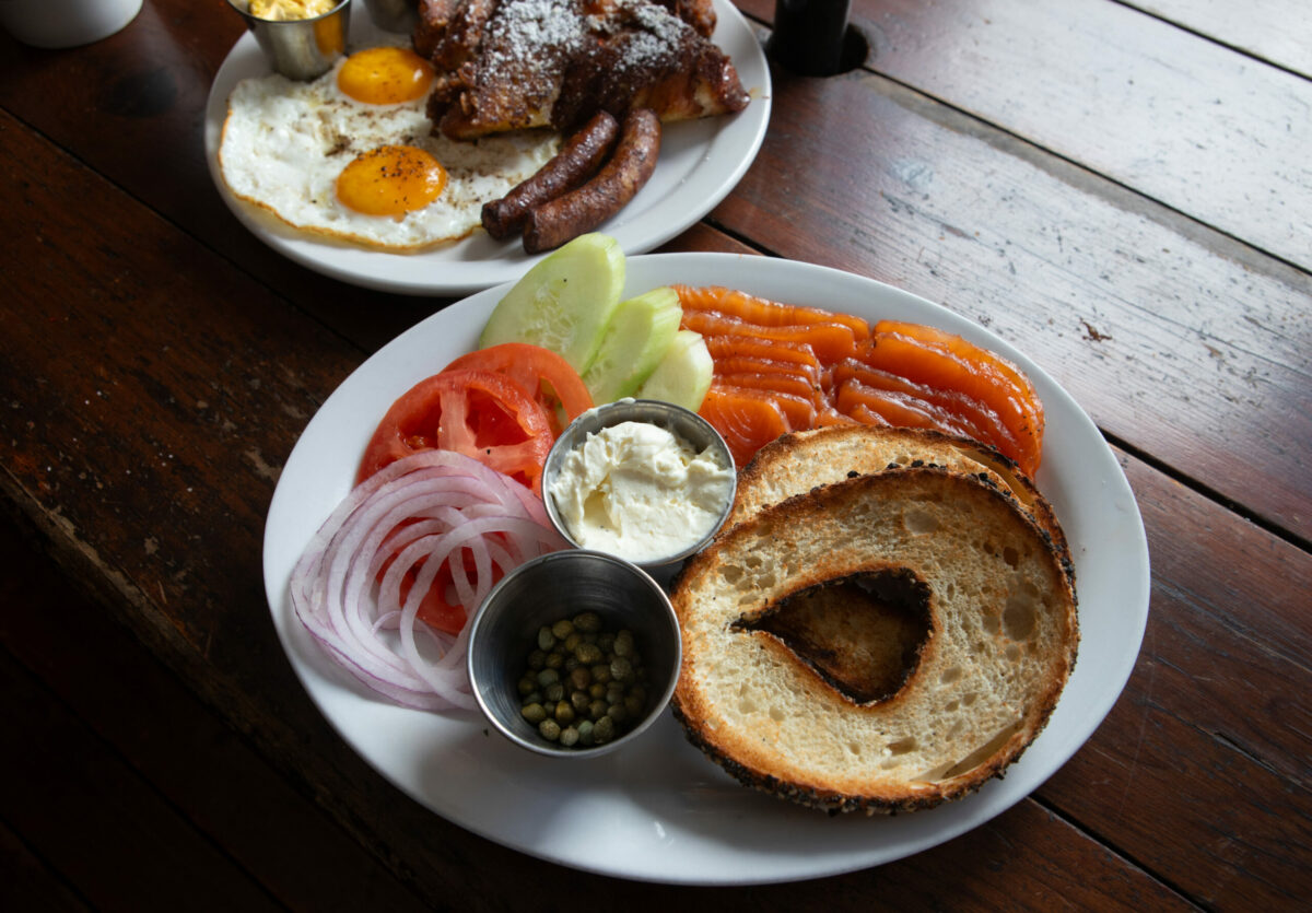 Brunch items include: Lox Plate with plain cream cheese, tomato, cucumber, onion, capers, and GB bagel, front center, with GB Cinnamon Babka French Toast in background at Grossman’s Noshery & Bar, in Santa Rosa, on Tuesday, July 2, 2024. (Darryl Bush / For The Press Democrat)