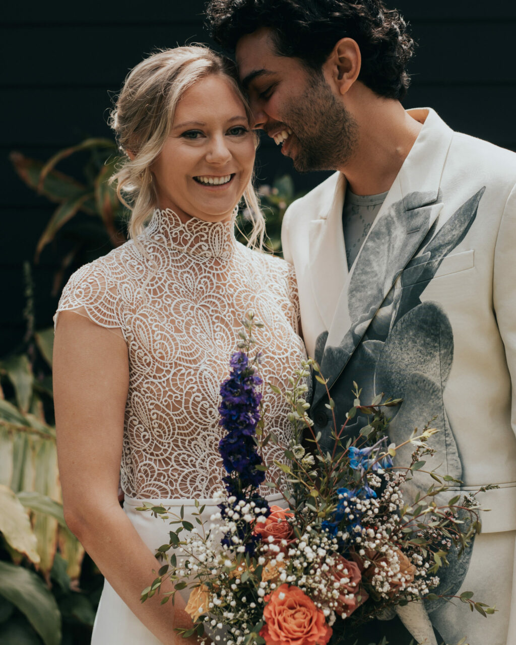 Megan and Ahmed Modan married in May of 2024. The morning of the wedding, Ahmed’s mother adorned Megan’s hands with intricate henna designs, improvising the pattern to complement the patterns in her wedding dress. Ahmed opted for a bold white suit with a graphic design to stand out from his groomsmen. (Amy DeBonis)