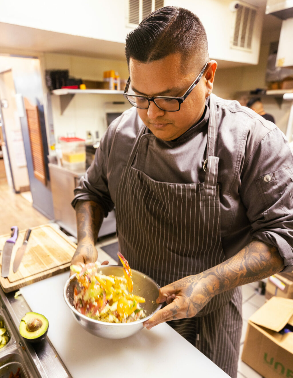 Chef Jorge Flores tosses his Peach Panzanella Salad made with Costeaux Bakery bread at the Healdsburg bakery, Friday, June 30, 2023. (John Burgess / The Press Democrat)