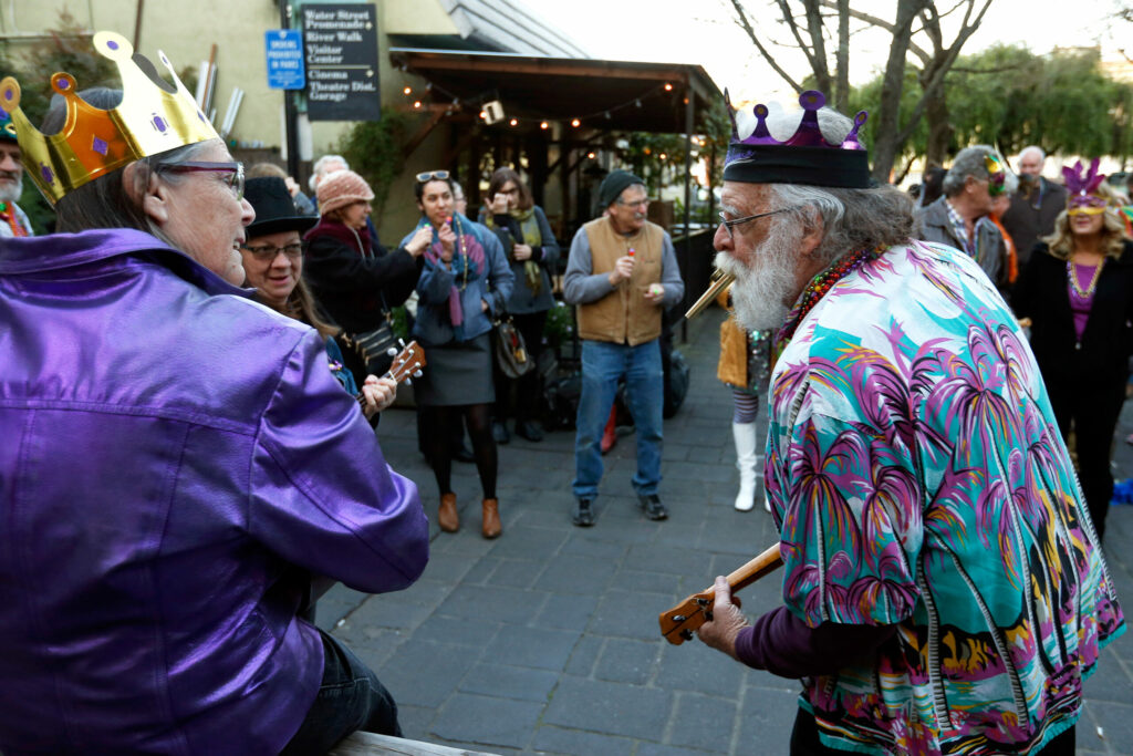 Dave Rampton, right, Mary Peterson, left, and Amy Johnson of the Petalukes ukulele club play festive songs to warm up the crowd of revelers before joining in a Mardi Gras parade at Putnam Plaza in Petaluma on Tuesday, February 28, 2017. (Alvin Jornada / The Press Democrat)
