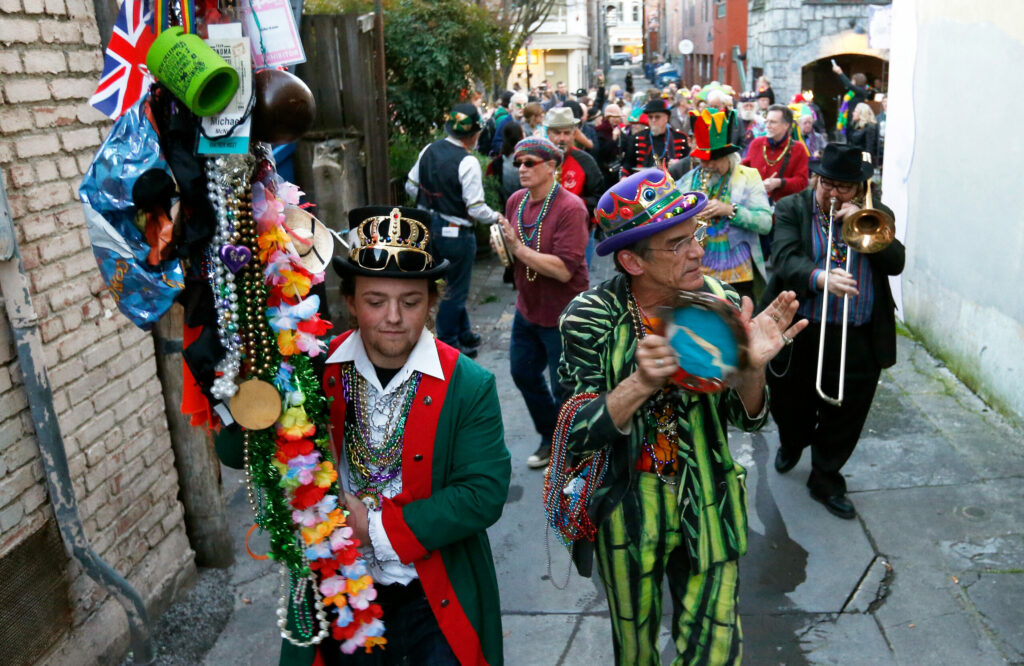 Alec McNeill, left, and Tim Eschliman with members of the Rhythmtown-Jive band lead a parade of Mardi Gras revelers in a parade down American Alley in Petaluma on Tuesday, February 28, 2017. (Alvin Jornada / The Press Democrat)
