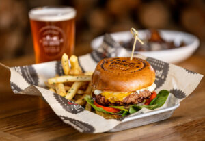 The Classic 1/2 Pound Burger with roasted garlic aioli, pickles, lettuce, red onion, tomato and cheddar and a side of Truffle Fries from Palooza Brewery and Gastropub Thursday, February 27, 2025 in Kenwood. (John Burgess / The Press Democrat)