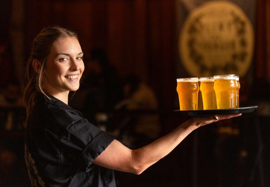 Server Stevye Wilhite with a tray of Pliny the Younger triple IPA Friday morning March 21, 2025 at the Russian River Brewing Co. in downtown Santa Rosa. (John Burgess / The Press Democrat)