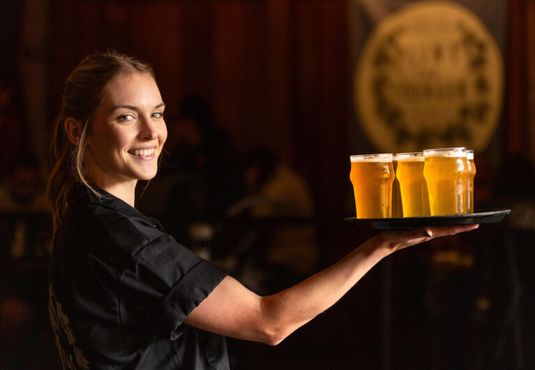 Server Stevye Wilhite with a tray of Pliny the Younger triple IPA Friday morning March 21, 2025 at the Russian River Brewing Co. in downtown Santa Rosa. (John Burgess / The Press Democrat)