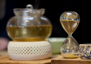 A 3-minute sand timer counts down as Chiang Dao Wild Mountain Green tea leaves steep in a pot at Two Trees Tea House in Occidental Wednesday, Feb. 12, 2025. (Beth Schlanker / The Press Democrat)