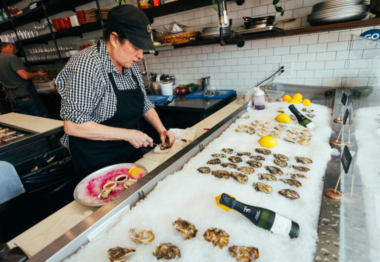 Mary Cecile Agneberg, the “MotherShucker,” brings a short knife and plenty of muscle when prying open mollusks at Trillium Winebar & Taproom Friday, February 28, 2025, on Main Street in Guerneville. (John Burgess / The Press Democrat)