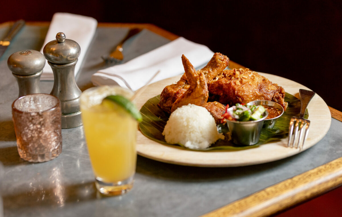 Hat Yai Fried Chicken with sticky rice, cucumber salad and sweet + sour sauce with a Mucho Micho cocktail from Underwood Bar and Bistro Friday, March 21, 2025, in Graton. (John Burgess / The Press Democrat)