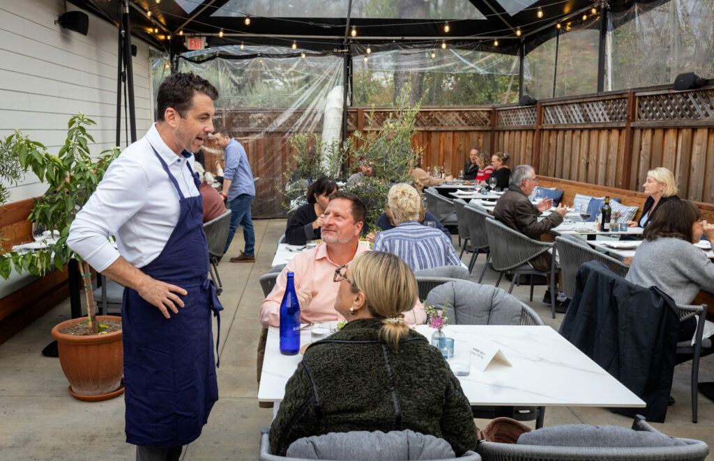 Glen Ellen Star chef/owner Ari Weiswasser chats with guests in the covered patio dining area at his new restaurant, Stella, on Highway 12 in the Sonoma Valley Wednesday, March 26, 2025, in Kenwood. (John Burgess / The Press Democrat)