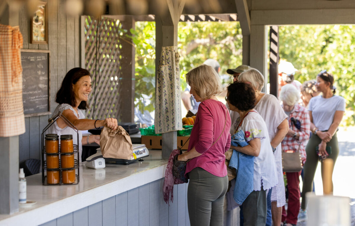 Guests visit the Dry Creek Peach and Produce farmstand and chat with owner Gayle Sullivan west of Healdsburg, Friday, Sept. 15, 2023. The farmstand is located on the Sullivans’ property. (John Burgess / The Press Democrat)
