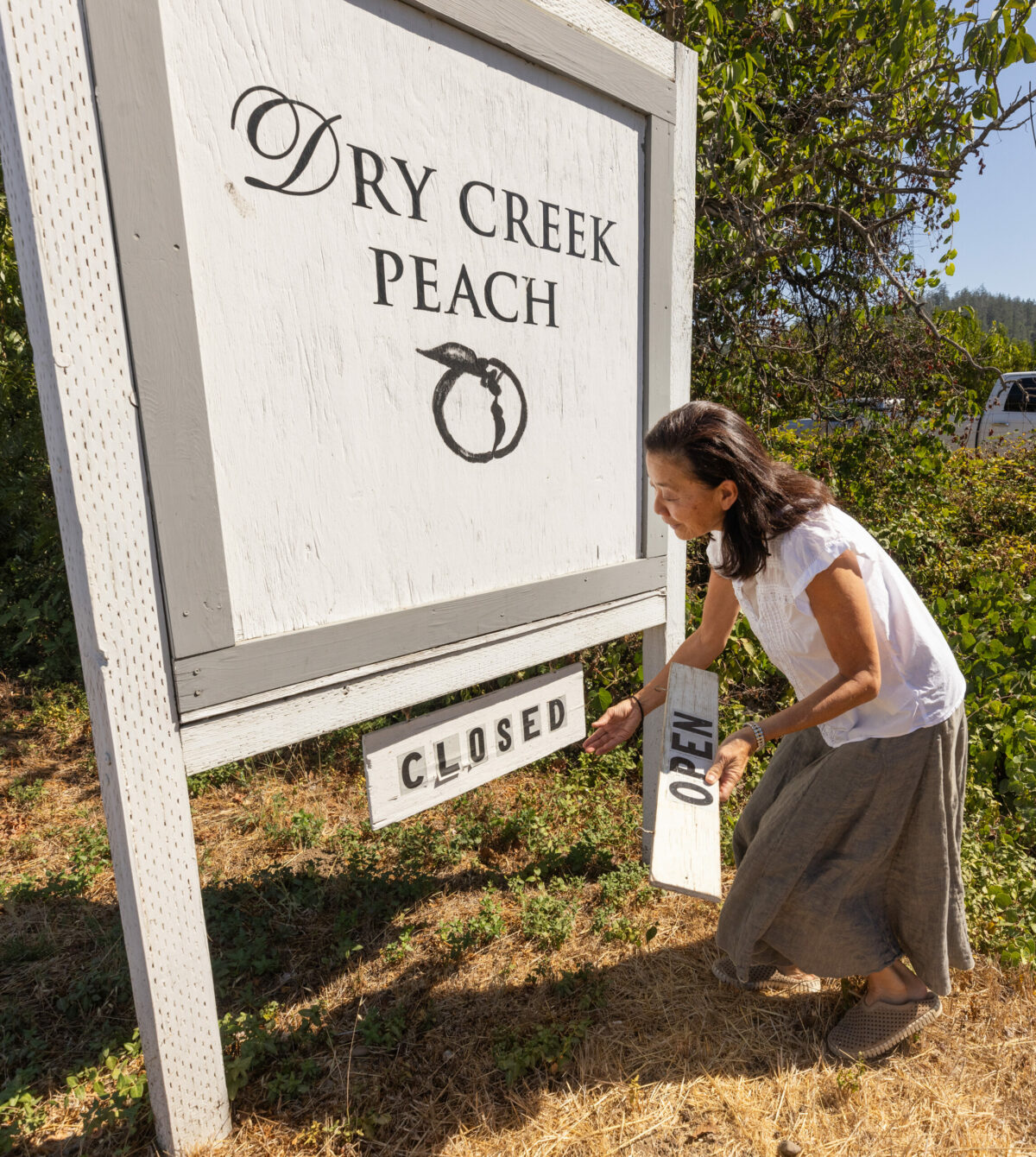 Dry Creek Peach and Produce owner Gayle Sullivan opens her farmstand on Yoakim Bridge Road in Dry Creek Valley, Friday, Sept. 15, 2023. (John Burgess / The Press Democrat)