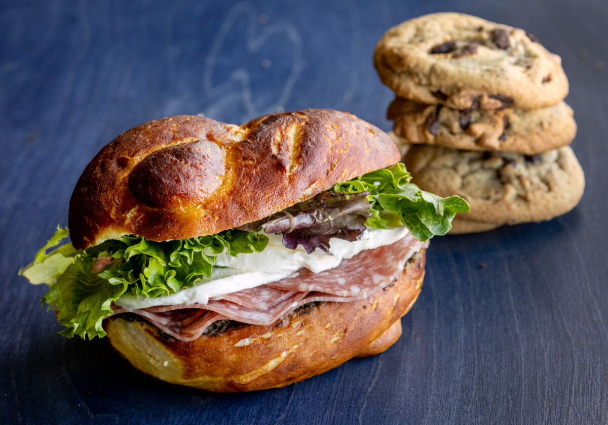 The Valencia Pretzel Sandwich with salami, mozzarella and house made olive tapenade and pesto with a cookie treat from the Wooden Petal Bake Shop Wednesday, September 11, 2024, in Santa Rosa. (John Burgess / The Press Democrat)