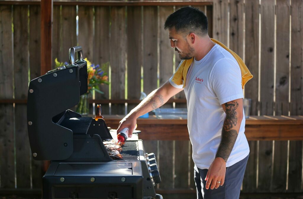 Justin Gill adds his Bachan's Japanese Barbecue Sauce onto grilled rib-eye in Santa Rosa on Wednesday, Sept. 11, 2019. (Christopher Chung/ The Press Democrat)