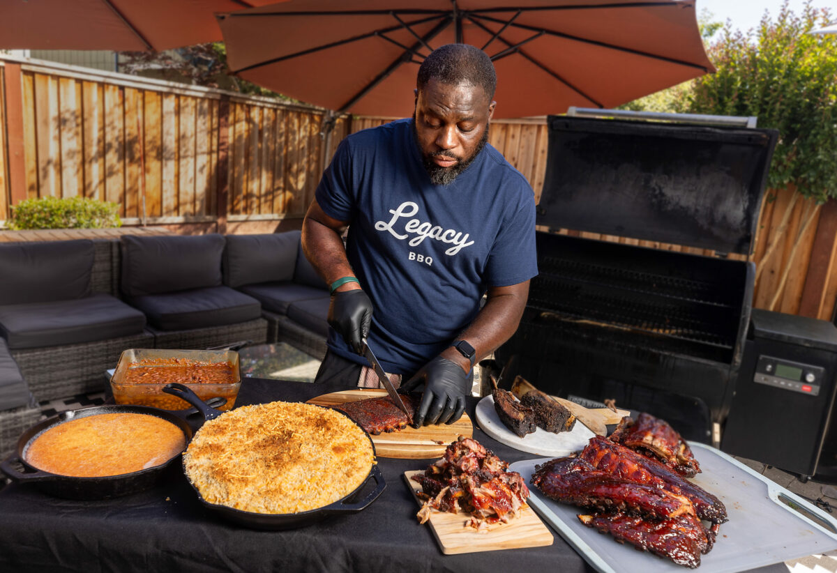 Joe Edwards III, owner of Legacy BBQ, cuts up smoked ribs for a backyard BBQ at his Santa Rosa home with Mac & Cheese, beans and corn bread Tuesday, June 11, 2024, in Santa Rosa. Edwards learned to cook from his father, the pitmaster at Porter Street BBQ in Cotati. (John Burgess/The Press Democrat)