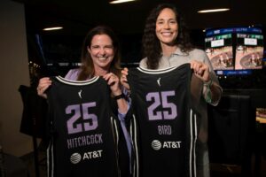 Nicole HItchcock and Sue Bird holding basketball jerseys