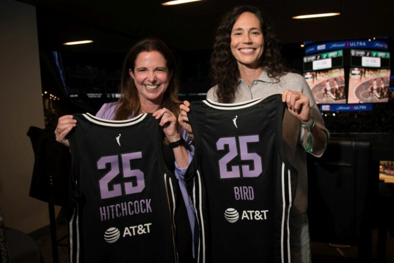 Nicole HItchcock and Sue Bird holding basketball jerseys