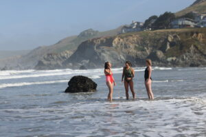 Morgan Filler, founder of See Her Swim, with friends Autumn Fuentes, in pink, and Ayla Mills, in black, at Dillon Beach near Tomales Wednesday, May 14, 2025. (Beth Schlanker / The Press Democrat)