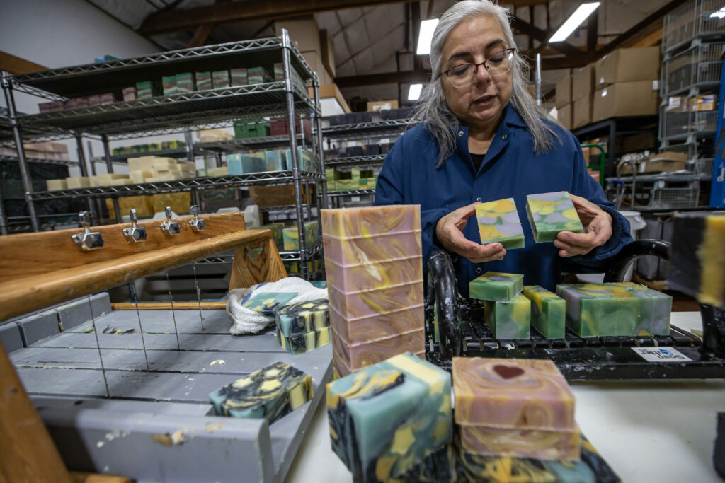 Emma Mann, Soap Cauldron owner, shows off a freshly cut batch of handmade soap while working in her production facility Monday in downtown Penngrove, November 28, 2023. (Chad Surmick / The Press Democrat)