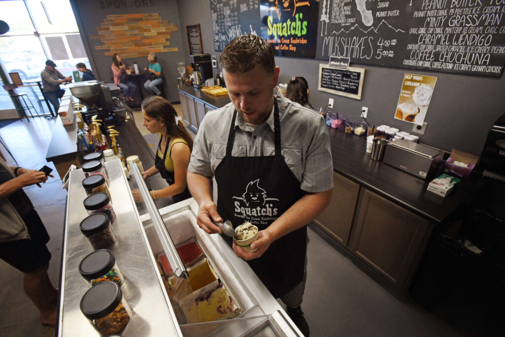 Lizzy Ergenbright, 14, works the register alongside co-owner Sean Sage at Squatch's Gourmet Ice Cream Sandwiches and Coffee in Rhonert Park on Saturday, July 10, 2021. The jobs at the shop are all voluntary, and Ergenbright said she appreciates the work experience to help her with future jobs. (Erik Castro/for The Press Democrat)