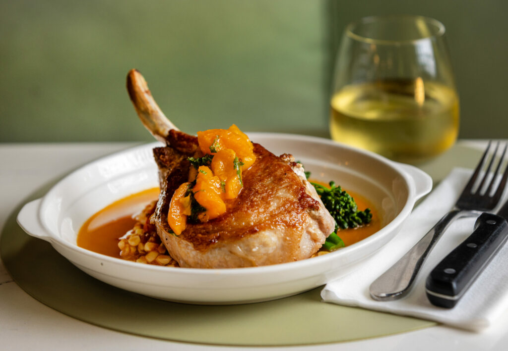 Pork Chop with summer corn, braised tomatoes, broccolini and apricot from The Burrow Wednesday, July 9, 2025 just off the square in Healdsburg. (John Burgess / The Press Democrat)